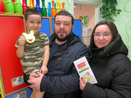 воспитанник с родителями держат памятку по ПДД и светоотражающий элемент воспитанник с родителями держат памятку по ПДД и светоотражающий элемент.